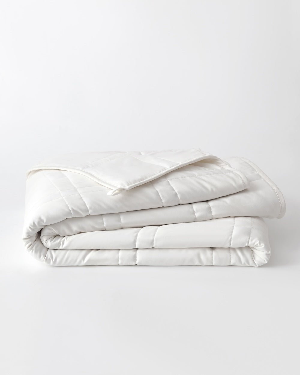A white cotton weighted blanket is folded on a plain background.  [42934587621595,42934587818203, 42934587850971, 42934587883739,46063268298971, 46301204906203, 46063268331739, 46301204938971, 46063268364507, 46301204971739, 46063268397275, 46301204873435, 46063269150939, 46730786603227, 46730786635995,46730786668763, 46730786701531, 47868895068379, 47868895101147, 47868895133915]