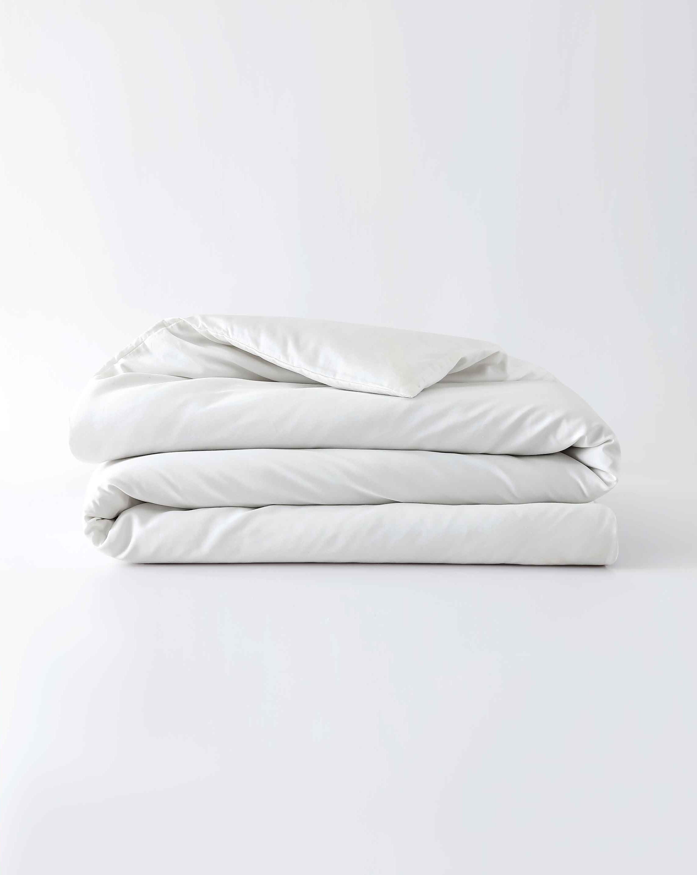 A white cotton duvet cover folded against an empty background [44422681886939,45027099410651,46063267610843,46063267643611,46063267676379,46063267709147,4606326839727546730800627931, 46730800759003, 46730800890075, 46730801021147, 47185819074779, 47185819205851]